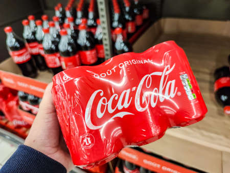Puilboreau, France - October 14, 2020: Closeup of Man hand buying pack of Coca Cola soft drink on...