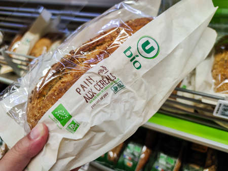 Puilboreau, France - October 14, 2020: Man buying organic cereal bread in the bakery section of a supermarketのeditorial素材