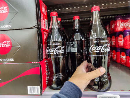 Puilboreau, France - October 14, 2020: Closeup of Man hand buying Original Coca Cola soft drink on...