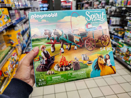 Puilboreau, France - October 14, 2020: Closeup of Man hand buying Playmobil Lego figurine brand display for sell in french supermarketのeditorial素材