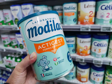 Puilboreau, France - October 14, 2020: A consumer chooses a box of Modilac brand baby milk from the baby food section of a supermarketのeditorial素材