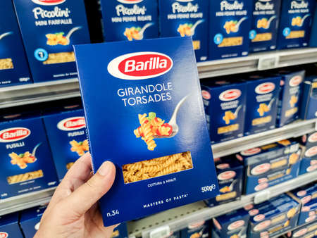 Puilboreau, France - October 14, 2020: Closeup of Man hand buying a package of girandole pasta Barilla brand display for sell in french supermarketのeditorial素材