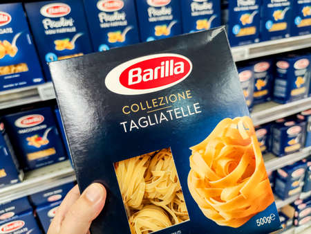 Puilboreau, France - October 14, 2020: Closeup of Man hand buying a package of tagliatelle pasta Barilla brand display for sell in french supermarketのeditorial素材
