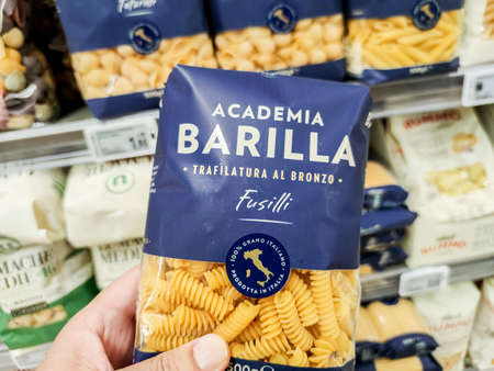 Puilboreau, France - October 14, 2020: Closeup of Man hand buying a package of fusilli pasta Barilla brand display for sell in french supermarketのeditorial素材