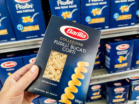 Puilboreau, France - October 14, 2020: Closeup of Man hand buying a package of fusilli pasta Barilla brand display for sell in french supermarketのeditorial素材