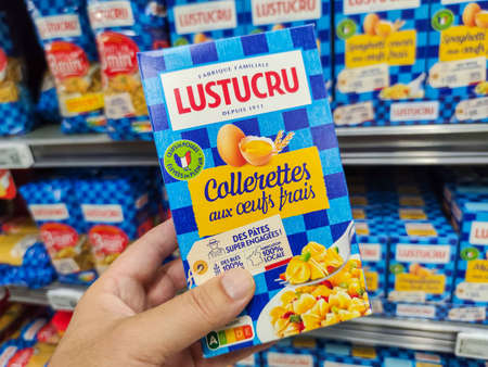 Puilboreau, France - October 14, 2020: Closeup of Man hand buying a package of collettes pasta Lustucru brand display for sell in french supermarketのeditorial素材