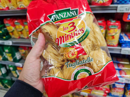 Puilboreau, France - October 14, 2020: Closeup of Man hand buying a package of Tagliatelle pasta Panzani brand display for sell in french supermarketのeditorial素材