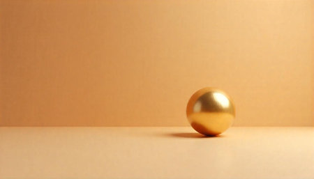 Golden sphere on beige background with subtle light playの写真素材