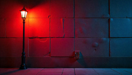 Illuminated street lamp casting a vibrant glow on city wallの写真素材