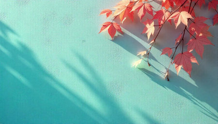 Autumn maple leaves against textured aqua wall with shadows