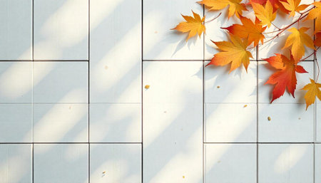 Autumn leaves cascading across a white tiled surface with sunlightの写真素材