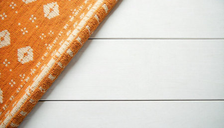 Orange patterned rug on white wooden planks backdrop