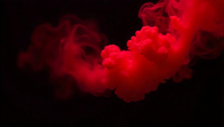 Abstract red smoke plume rising against black background studio
