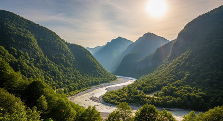Majestic mountains with river flowing through lush green valleyの写真素材
