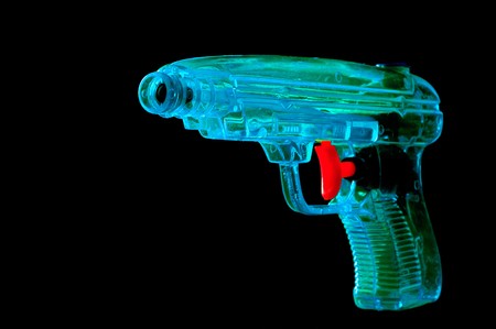 Blue water pistol with a red trigger on black backgroundの写真素材