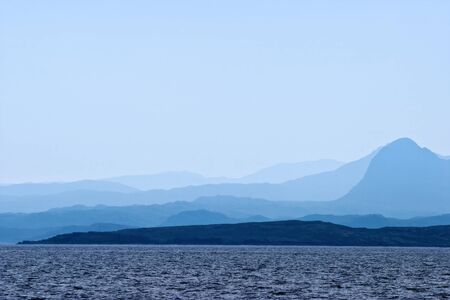 Rocky Coastline with mountain silhouetteの写真素材