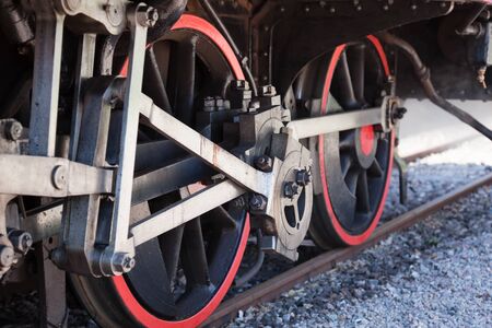 The wheels on an old steam engine