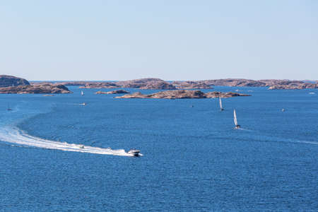 Rocky archipelago with motor boats at seaの写真素材