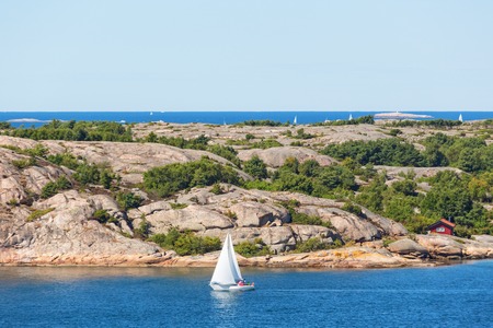 Rocky archipelago with a sailing boat の写真素材