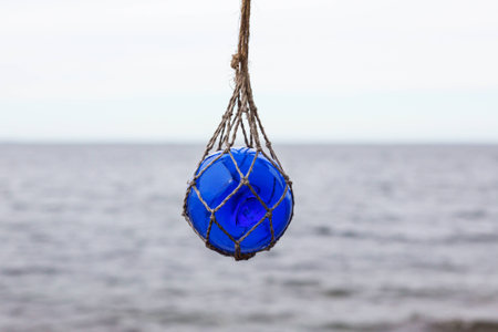 Blue glass buoy hanging in a net