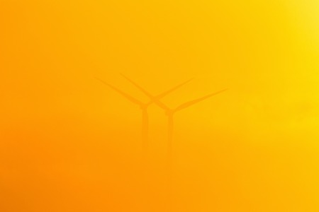 Wind turbines in misty sunriseの写真素材