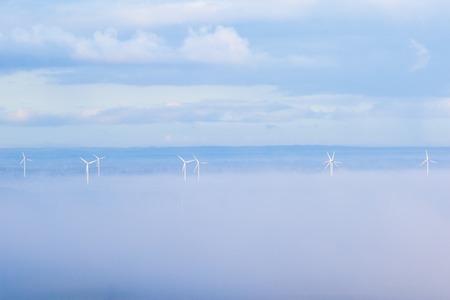 Wind power in misty landscapeの写真素材