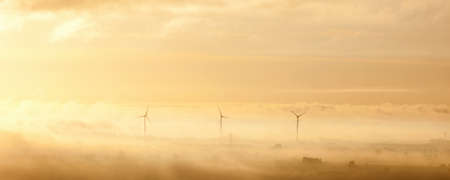 Wind turbines in the morning misty lightの写真素材
