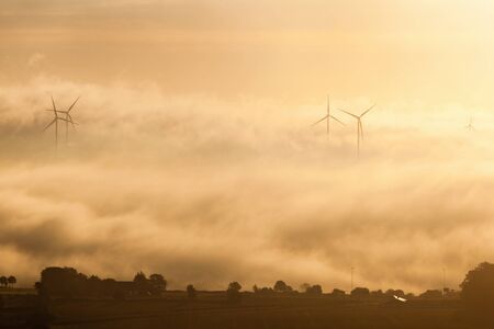 Wind turbines in misty countryside lndscape