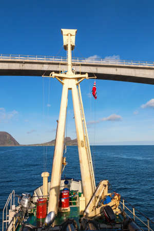 Vessel going under a bridge to the seaの写真素材
