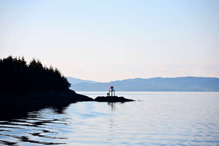 Coastline in silhuoette with a small lighthouseの写真素材