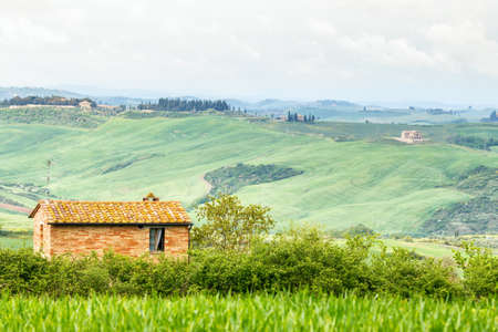 Rural Italian landscape with a small cottage at a valleyの写真素材