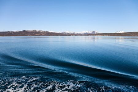 Norwegian coast landscape with snow on the mountainの写真素材