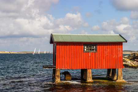 Red boathouse by the seaの写真素材