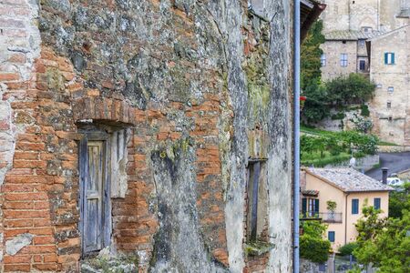 Old weathered window on a brick wall in a villageの写真素材