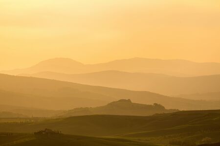Sunset over a rolling landscapeの写真素材