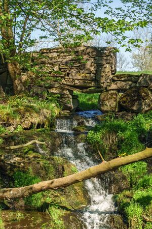 Waterfall in a creek in an old stone wall