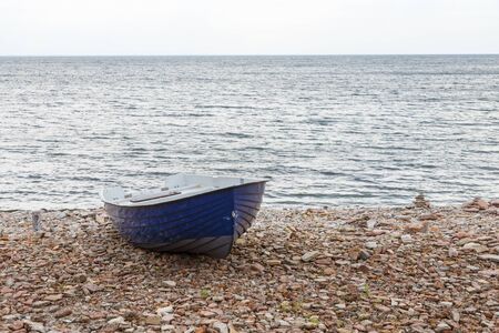 Rowing boat at a pebble beach by the sea