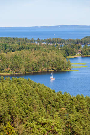 Sailboat on the water in a forest lakeの写真素材