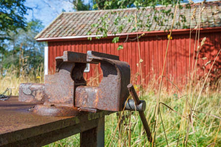Old rusty vise on a workbench in the gardenの写真素材