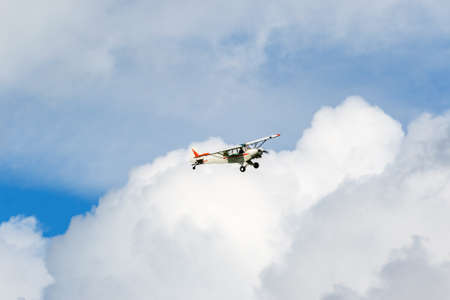 Aircraft flying in the clouds in the skyの写真素材
