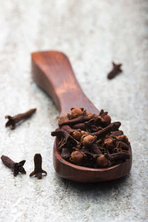Macro closeup image of dried cloves in wooden spoon. Used as spices and aroma.の写真素材