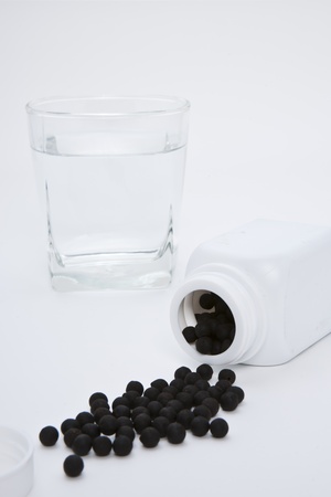Herbal medicine pill with a glass waterの写真素材