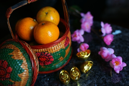 Basket of Apples and Oranges with Gold ingots and plum blossomの写真素材