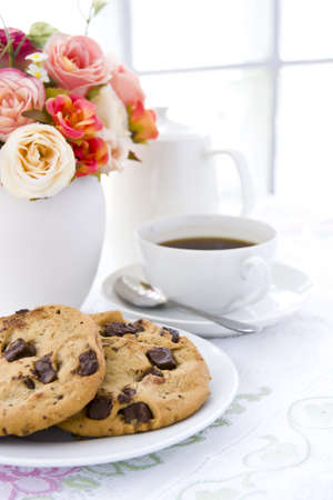 Chocolate chip cookie  on white plate with black coffee and flowerの写真素材