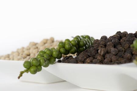 Hot and Spicy Black, White and Green Pepper on white backgroundの写真素材