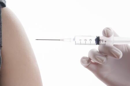 Doctor / Nurse holding a syringe give an injection, on white backgroundの写真素材