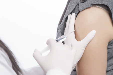 Doctor / Nurse holding a syringe give an injection, on white backgroundの写真素材