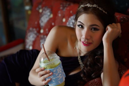 Young Asian woman holding a green tea smoothieの写真素材