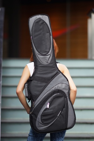 Young beautiful woman posing outdoor with her guitar gig bag,
model is Thai Ethnic.の写真素材