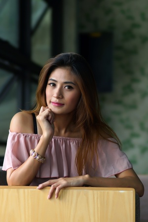 Beautiful young woman posing alone in the cafe, Model is Thai Ethnicity.の写真素材